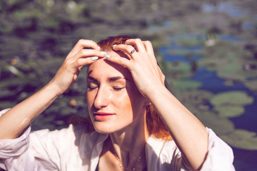 Frau streicht sich die Haare aus dem Gesicht