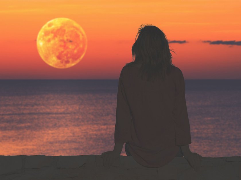 Girl watching the ocean / sea horizon with a Moonrise.