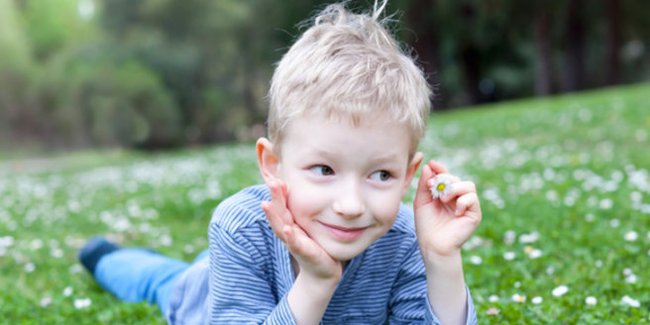 Epilepsie bei Kindern: Junge liegt im Gras
