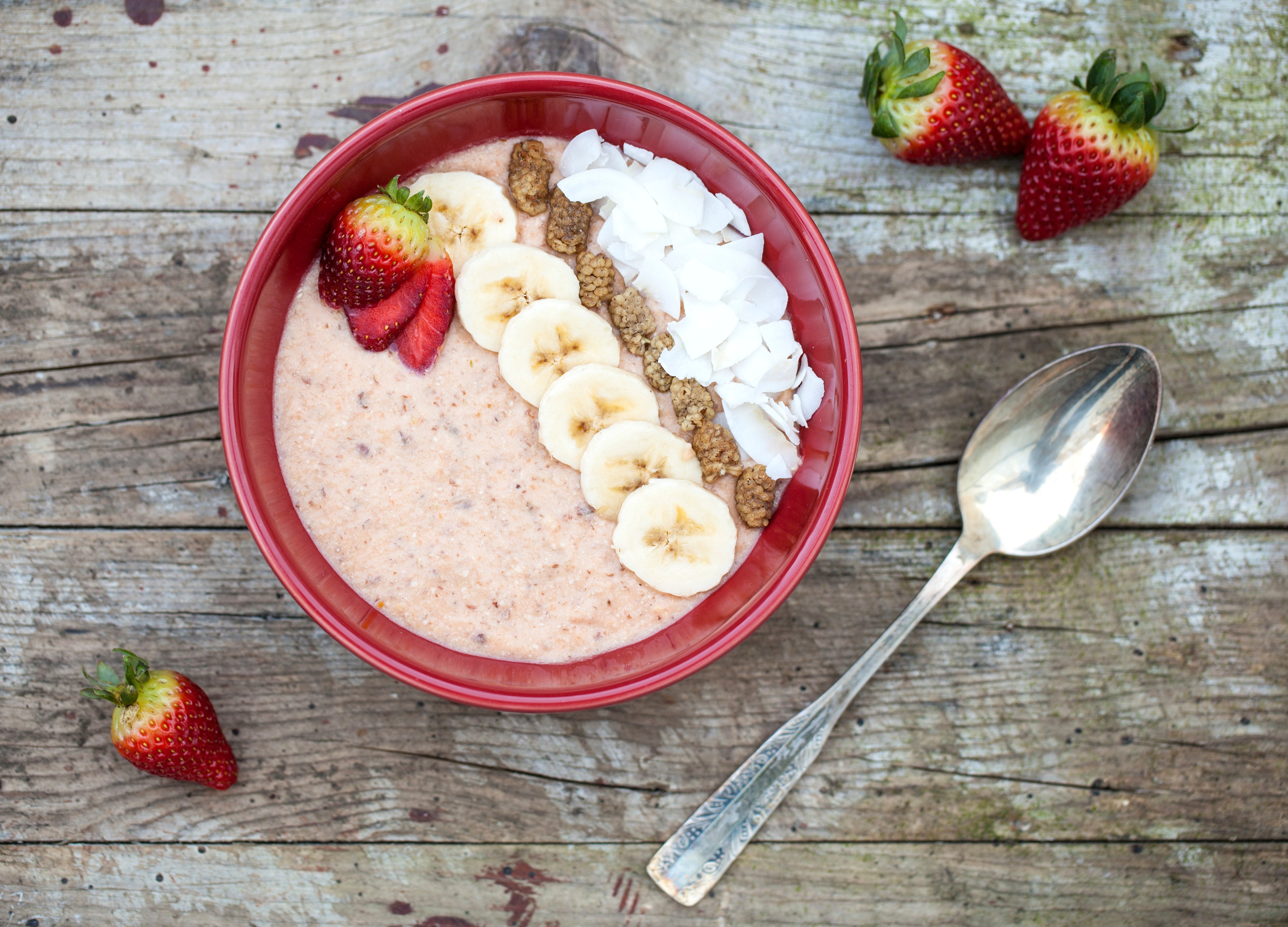 Porridge mit Bananen, Erdbeeren und Cocos-Chips Porridge mit Bananen, Erdbeeren und Cocos-Chips