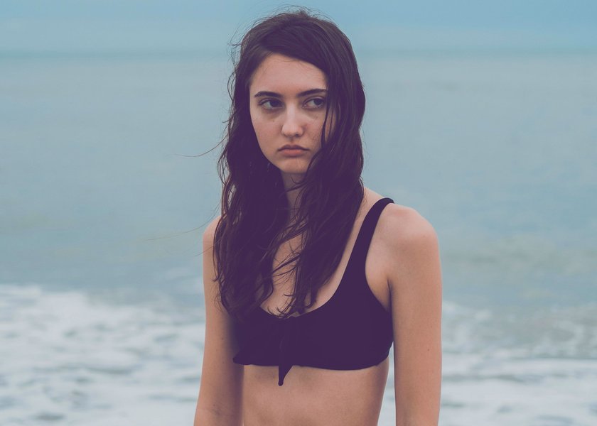 junges Mädchen steht im Bikini im Meer