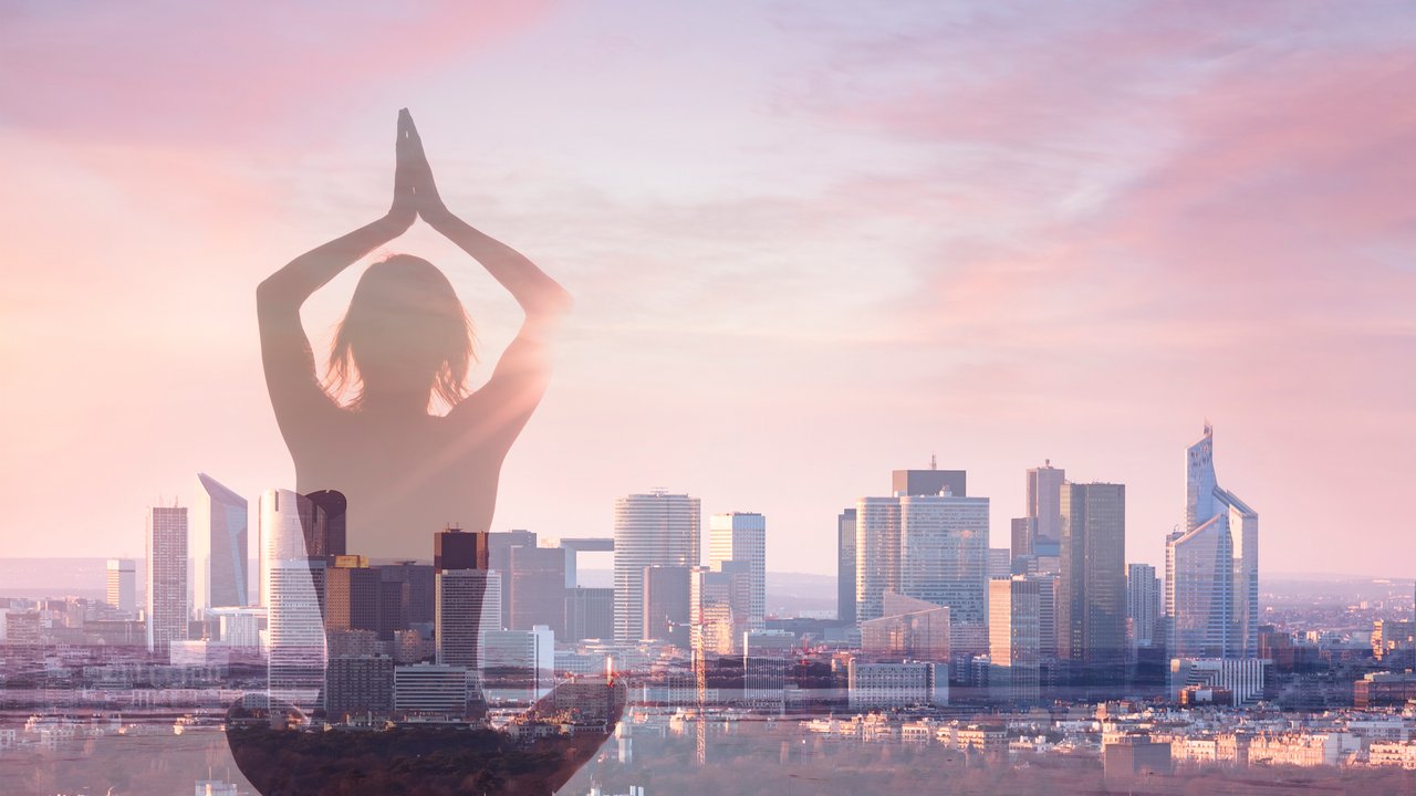 Double exposure of woman practicing yoga and city background with office building, concept about revitalizing in modern business life