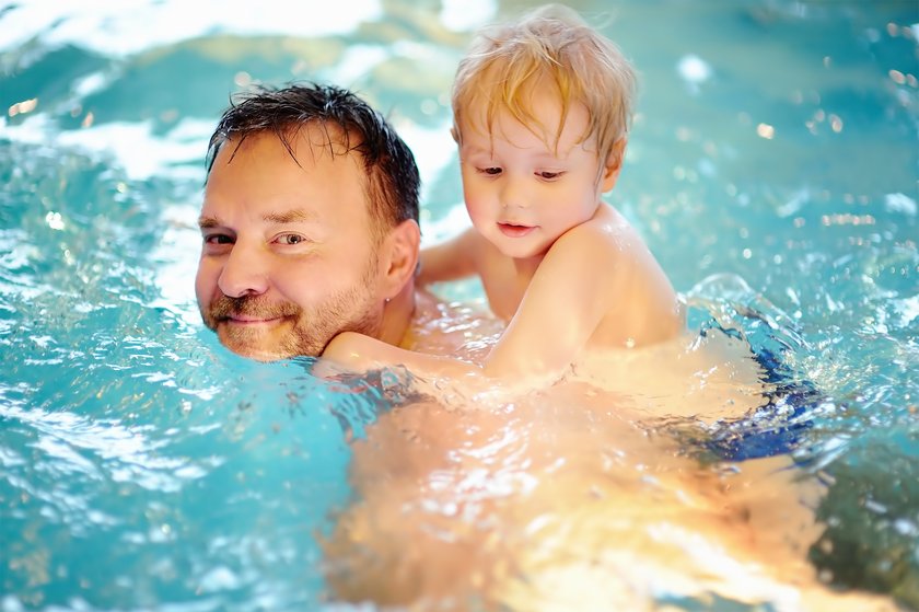 Vater und Sohn schwimmen im Pool