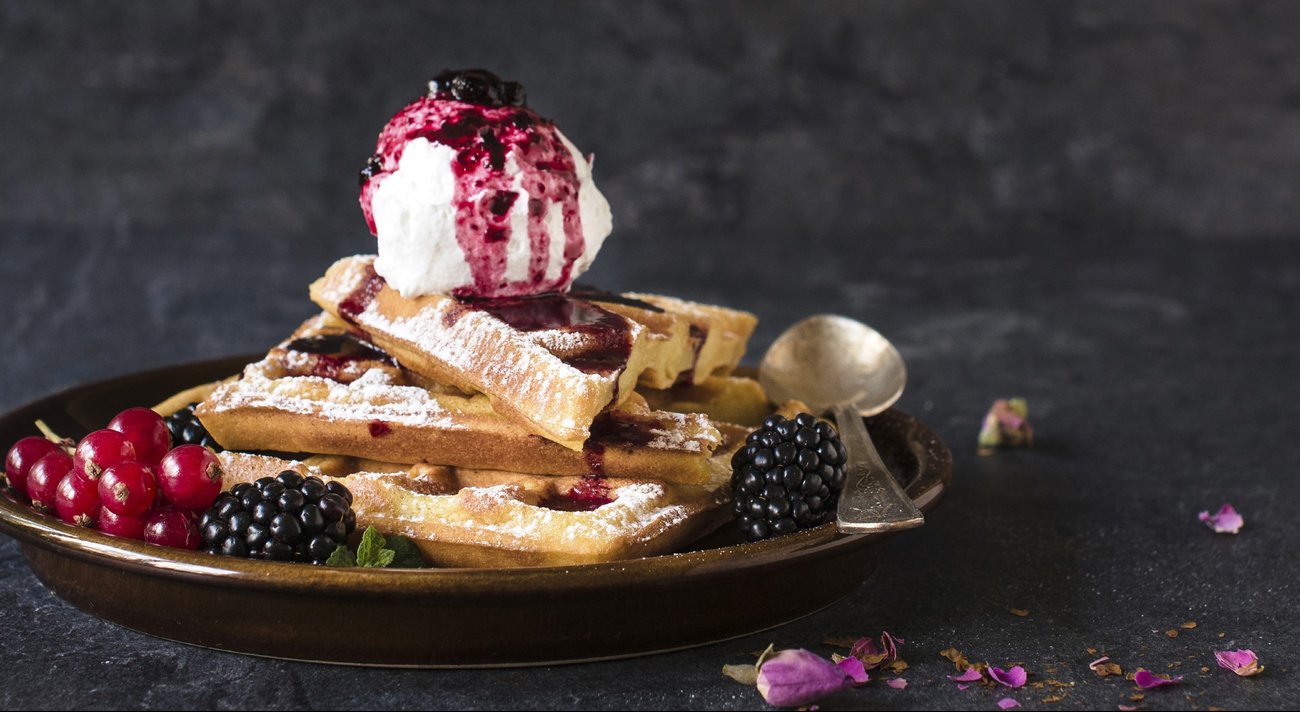 Baked traditional Belgium waffles with ice cream and berry fruit sauce,selective focus and blank space Baked traditional Belgium waffles with ice cream and berry fruit sauce,selective focus and blank space