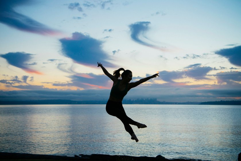 Silhouette einer jungen Frau die ins Wasser geht