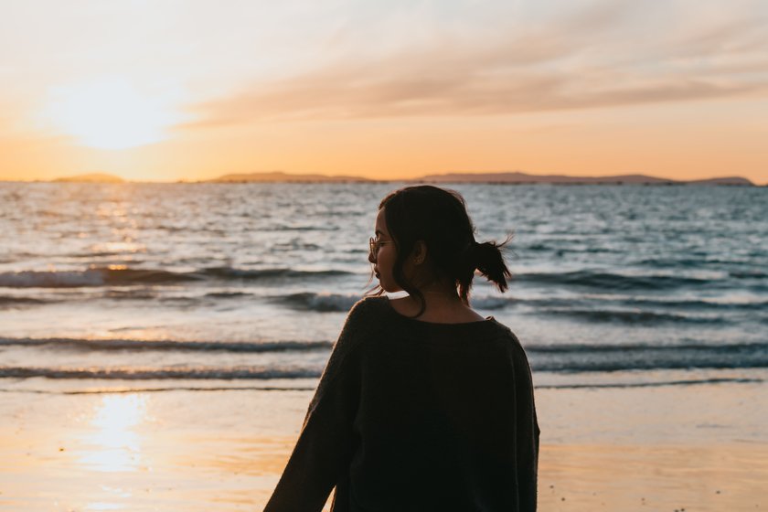 Silhouette einer Frau am Strand vor dem Meer