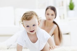 Baby, 10 Monate, krabbelt weg von Mama Baby, 10 Monate, krabbelt weg von Mama