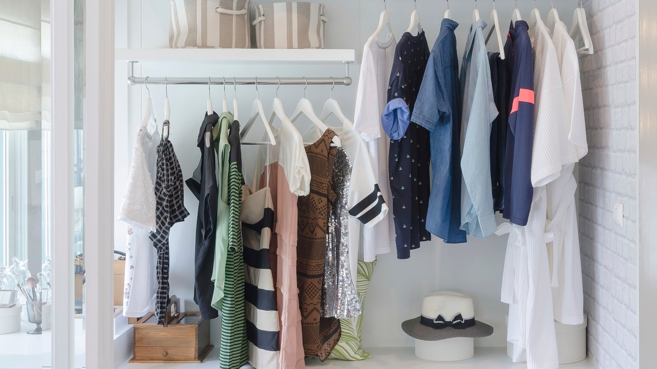 clothes hanging in closet with hat at home