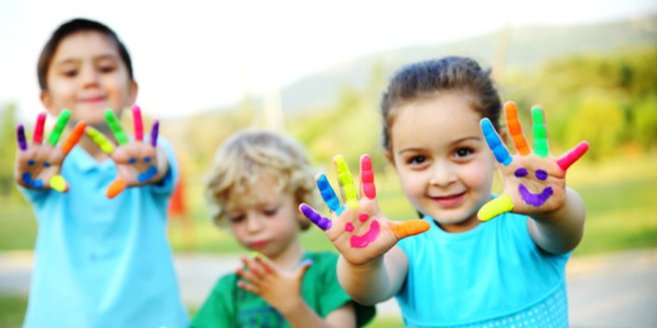 Spielend lernen: Kinder zeigen ihre mit Fingerfarben bemalten Hände