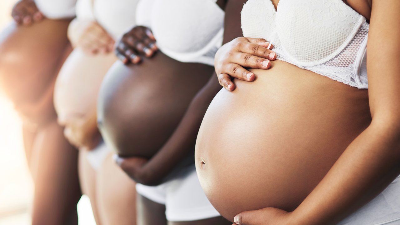 Cropped shot of a group of unrecognizable young pregnant women standing in a row with their hands on their bellies