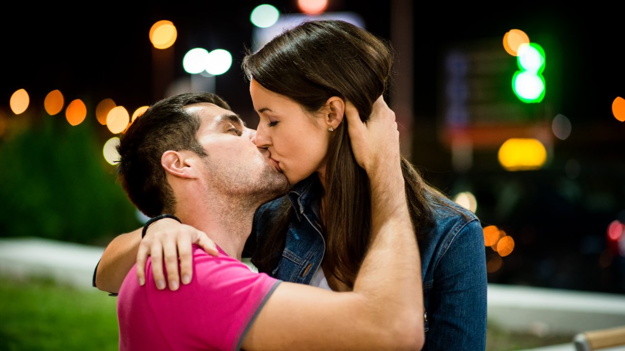 Couple together on date in street with neon lights at night