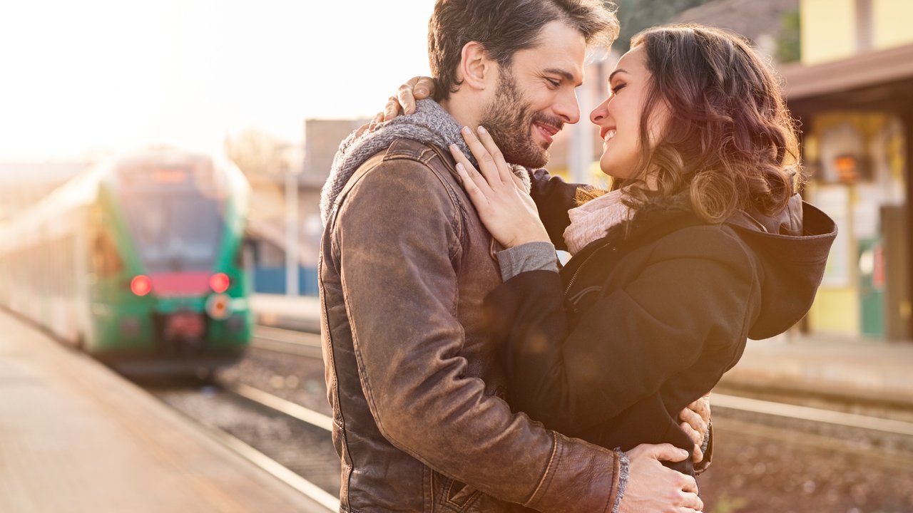 Happy couple embracing on railway station platform
