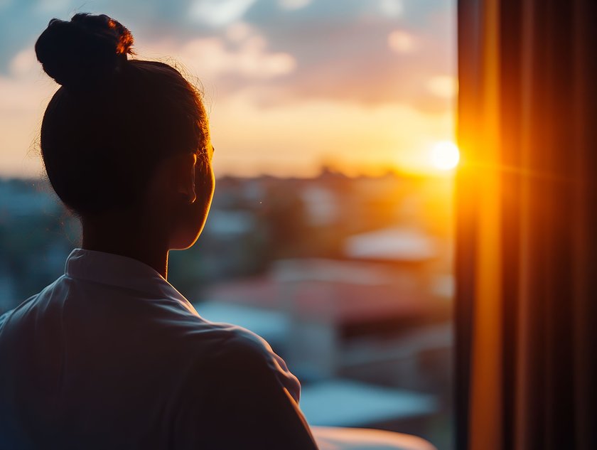 Frau schaut aus einem Fenster