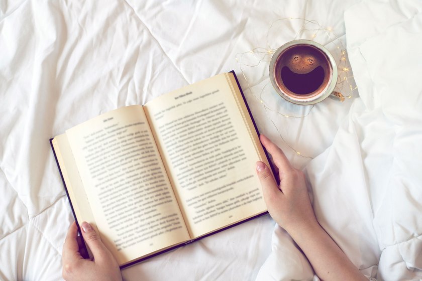 Aufgeschlagenes Buch auf einer Bettdecke