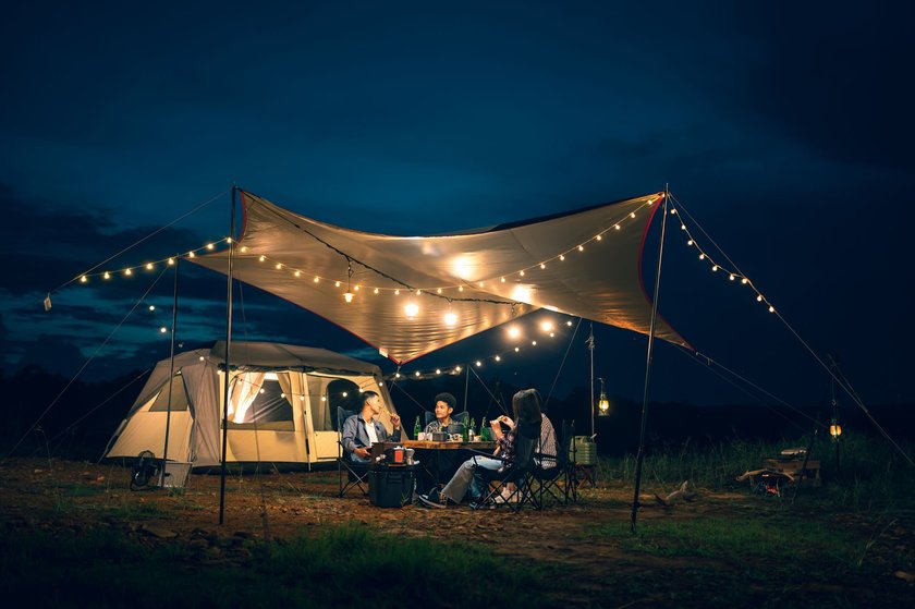 Freunde beim Campen mit Lichterketten