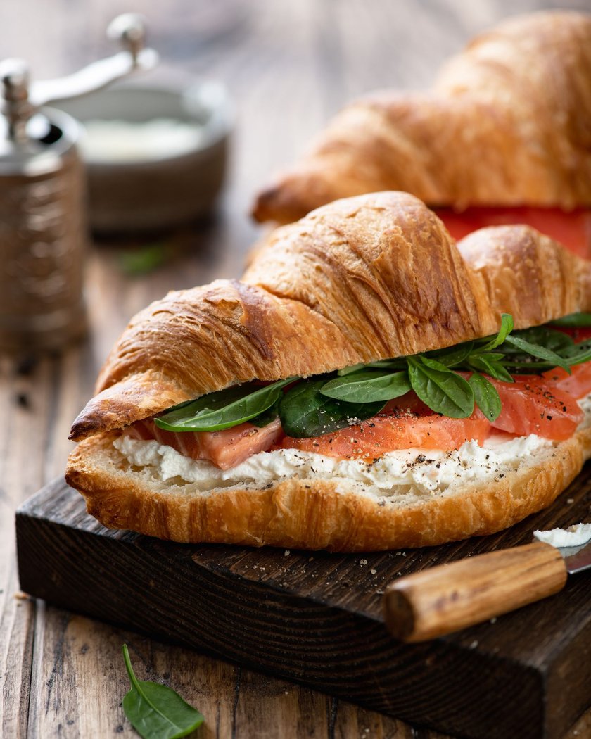 sandwich with salmon, spinach and cream cheese on a wooden board, selective focus, close-up