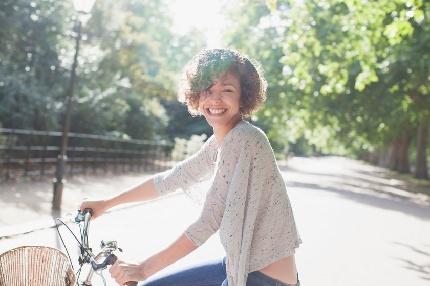 Frau lächelt und sitzt auf einem Fahrrad