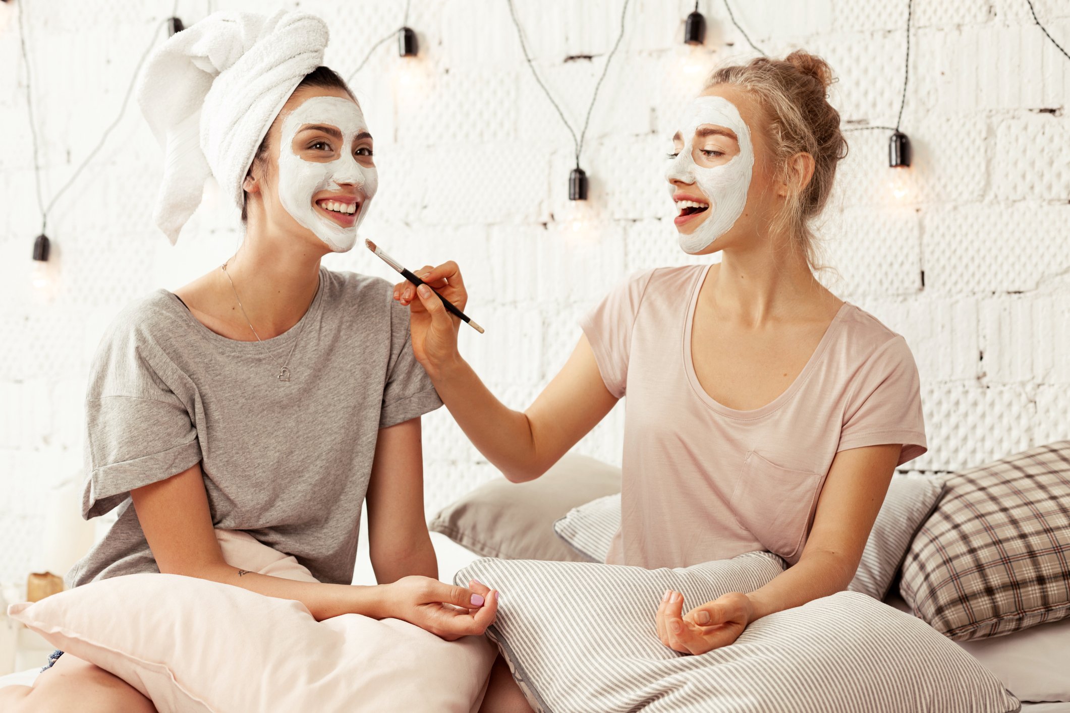 Frauen tragen sich gegenseitig Gesichtsmasken auf Frauen tragen sich gegenseitig Gesichtsmasken auf