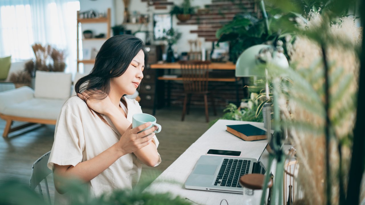 Asian woman struggling with using laptop at home