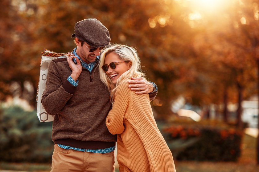 Portrait eines jungen Paares, das im Herbst in die Stadt läuft.