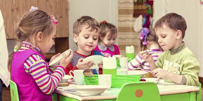 Betriebskindergarten: Kinder sitzen am Tisch Betriebskindergarten: Kinder sitzen am Tisch