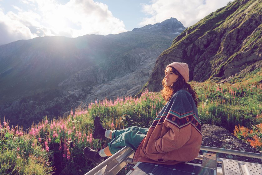 Frau sitzt in den Bergen