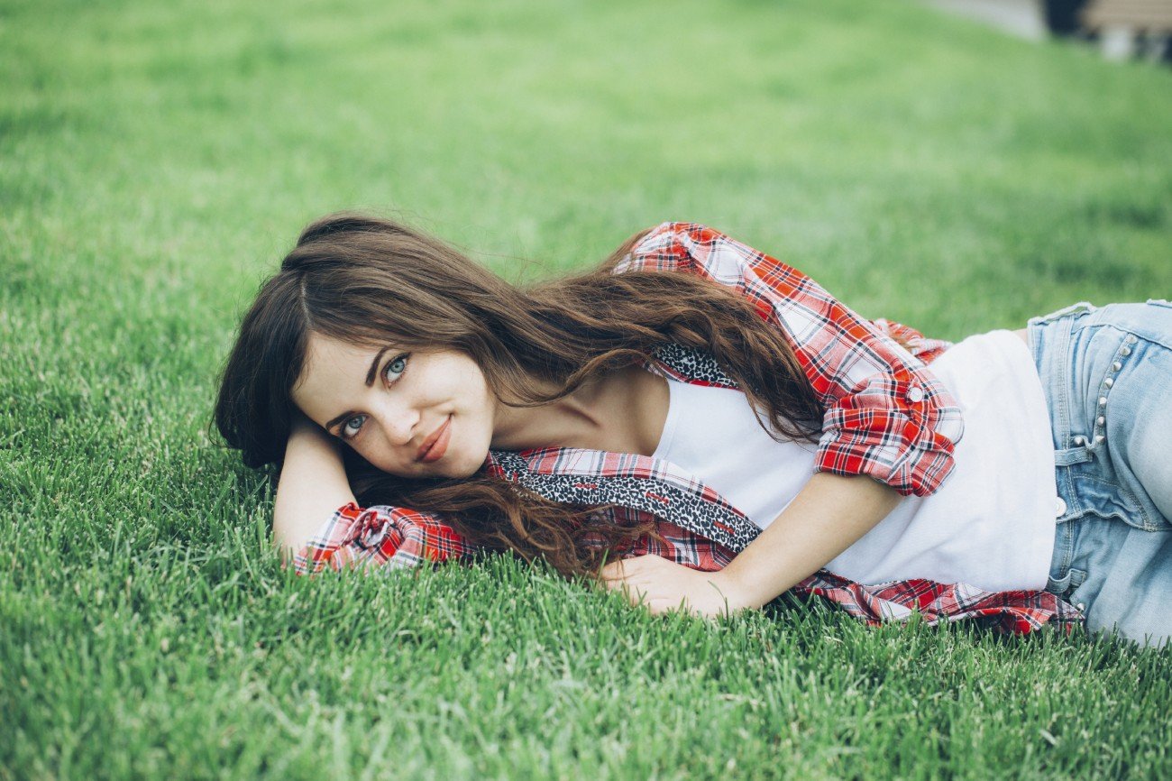 Beautiful girl student resting on the grass.
