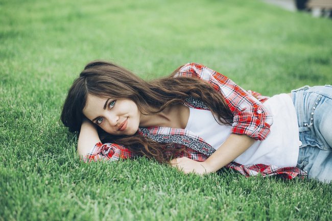 Beautiful girl student resting on the grass. Beautiful girl student resting on the grass.