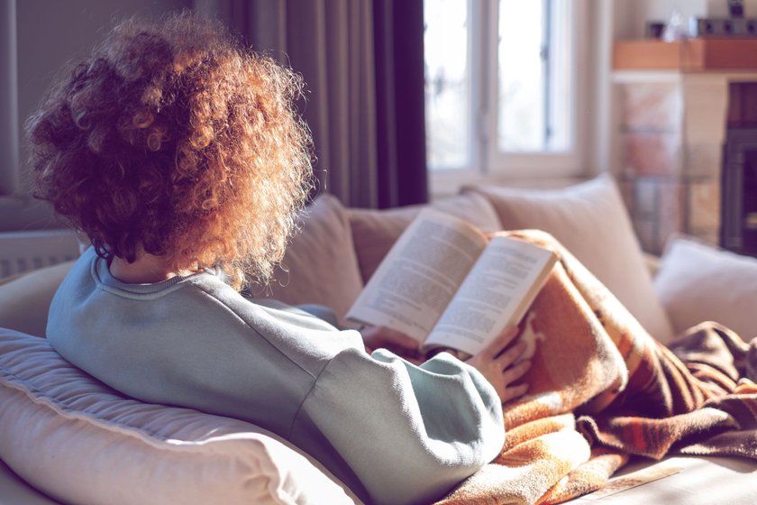 Frau liest auf Couch