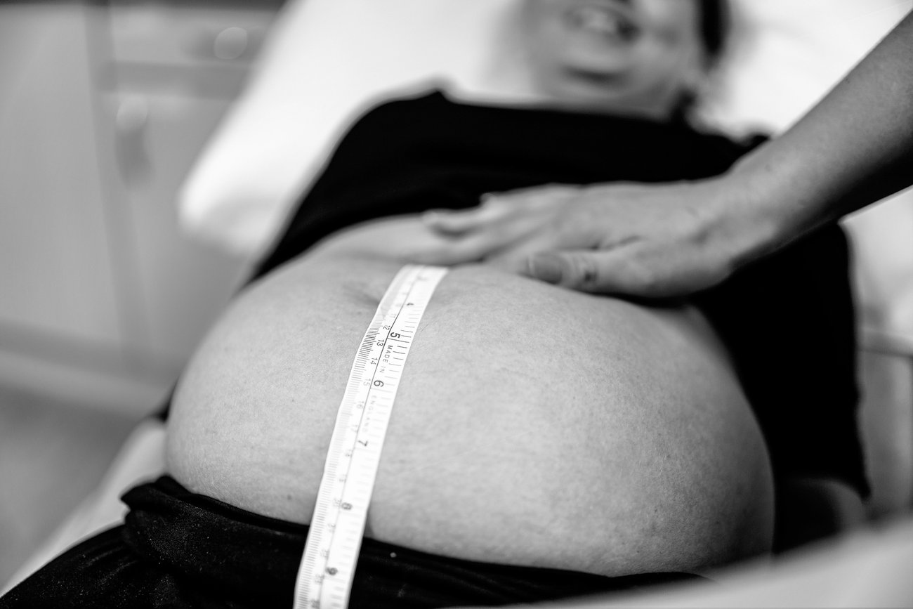 Hebamme misst Bauch von schwangerer Frau Hebamme misst Bauch von schwangerer Frau