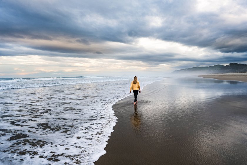 Junge Frau läauft an einem wunderschönen Strand entlang