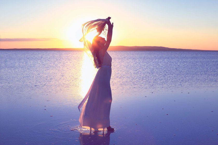 Frau am Strand im Sonnenuntergang