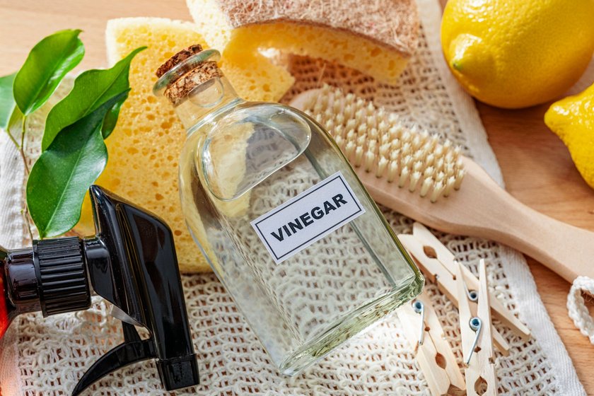 Home cleaning with natural and eco friendly products. Bottle of white vinegar for cleaning purposes. Lemons, scrubbing brush and cleaning sponge complete the composition. High resolution 42Mp studio digital capture taken with Sony A7rII and Sony FE 90mm f2.8 macro G OSS lens