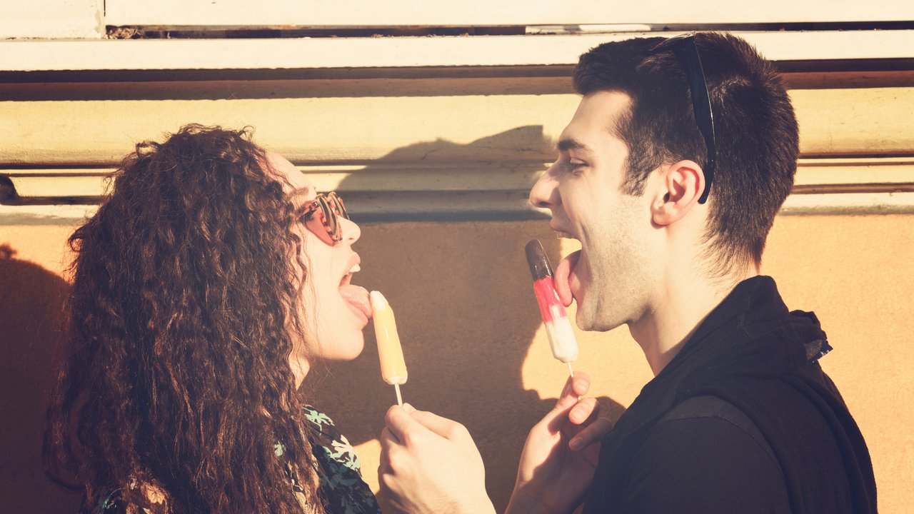 Urban couple outdoors eating ice-cream on the street.