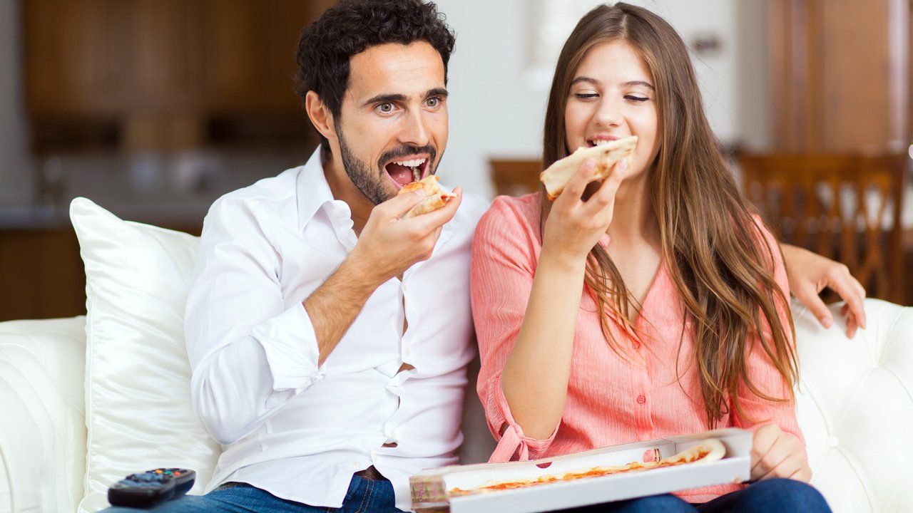 Couple with pizza and TV remote
