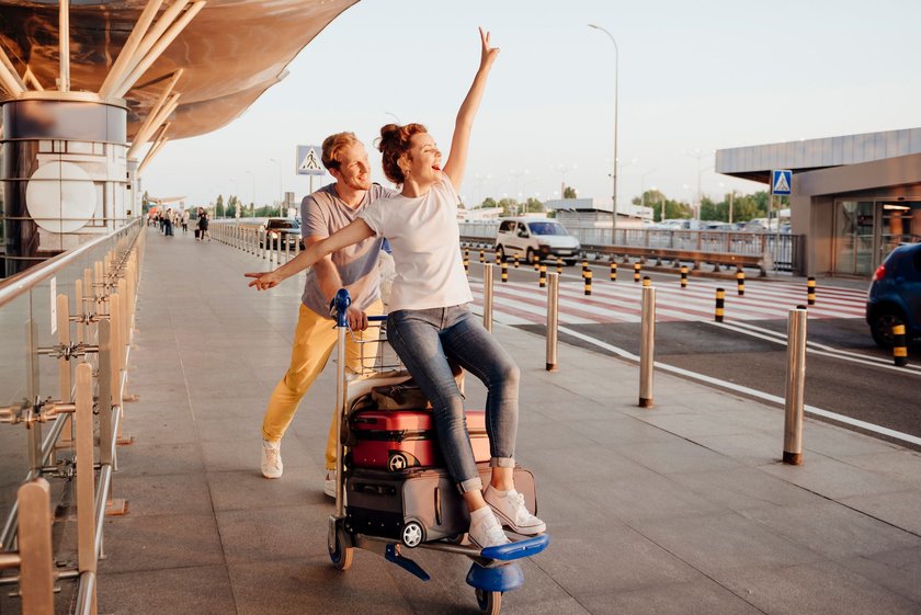 Paar am Flughafen mit Koffern