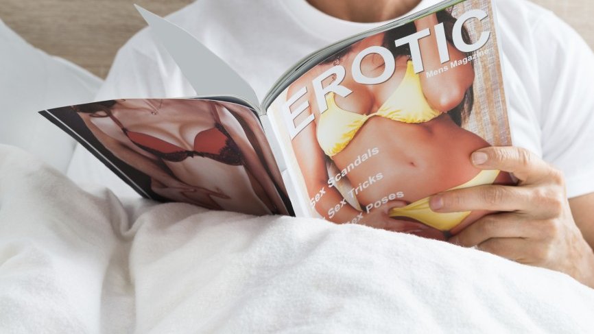 Close-up Of A Man Holding Magazine At Home