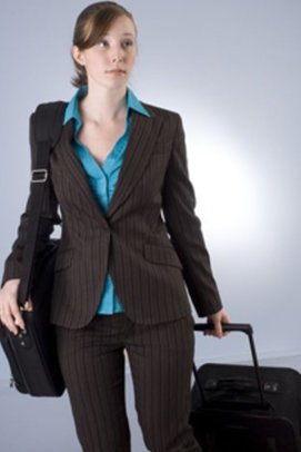 brünette Frau in Businesskleidung trägt eine Laptoptasche und einen Koffe und schaut besorgt brünette Frau in Businesskleidung trägt eine Laptoptasche und einen Koffe und schaut besorgt