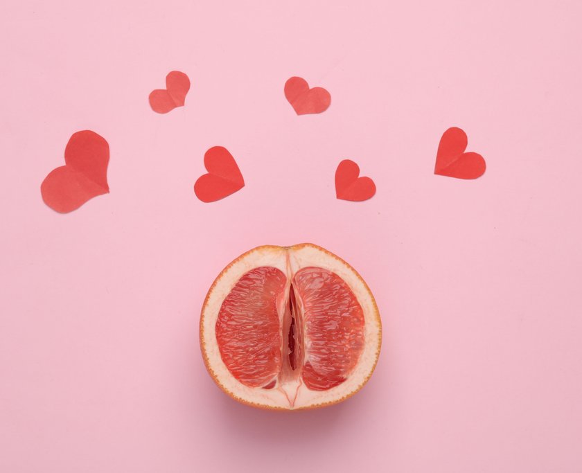 Gynecology, female intimate hygiene, love, sex concept. Half of ripe grapefruit symbolizing the female vagina and hearts on pink background. Top view