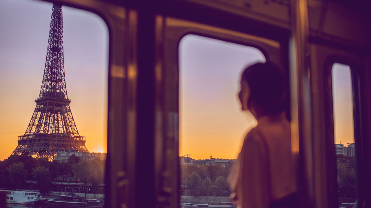 Frau in der Bahn schaut auf den Eiffelturm
