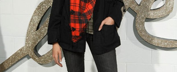 Model Agyness Dean trägt eine Röhrenjeans, Turnschuhe und eine weite Jacke mit Halstuch im Boyfriend-Look