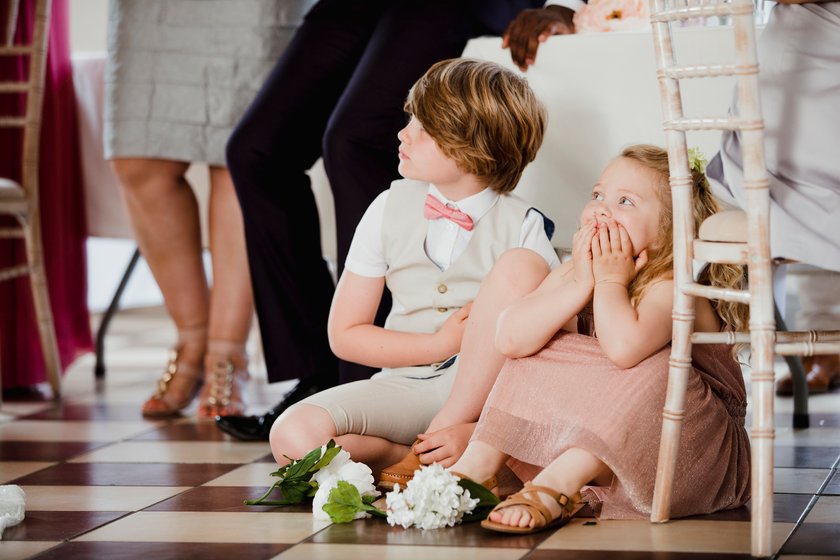 Kinder sitzen bei einer Hochzeit auf dem Boden