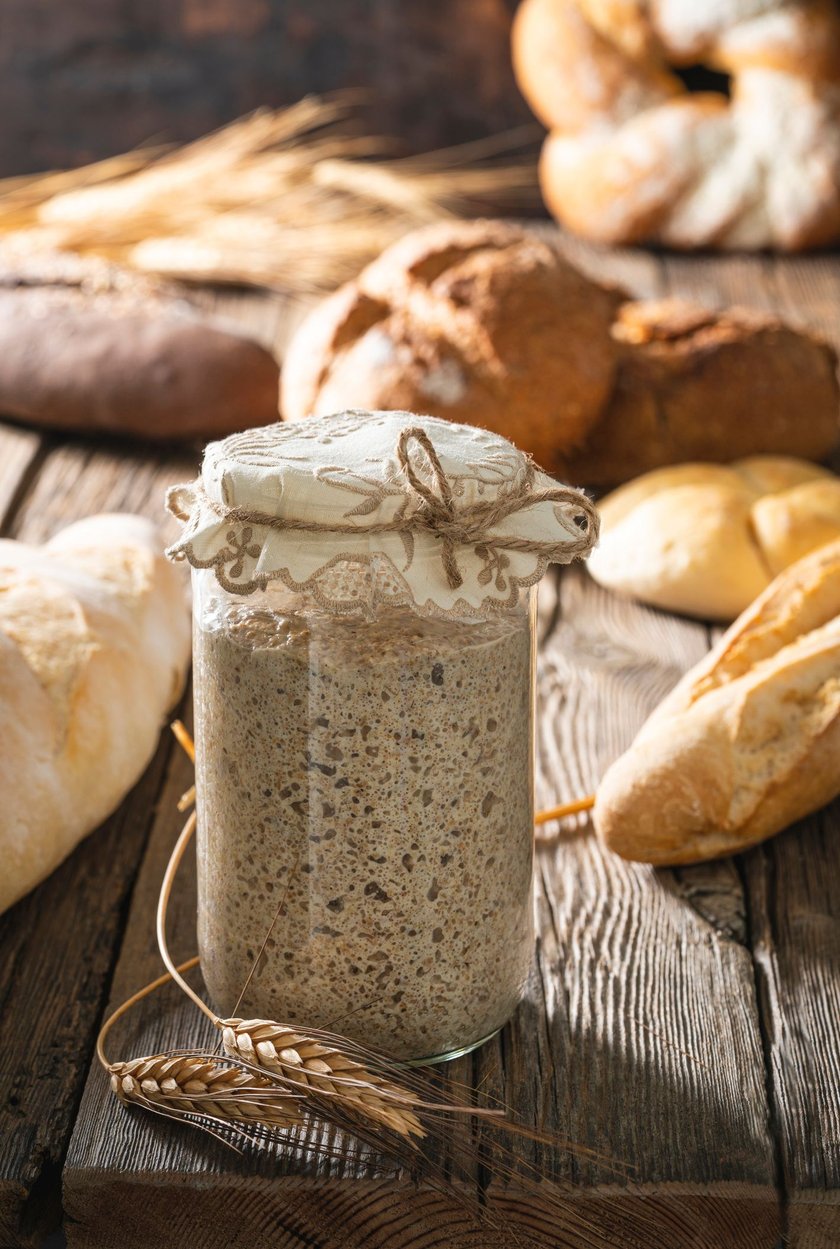 Sourdough starter for bread and bakery leavening agent levain on rustic wooden table board background