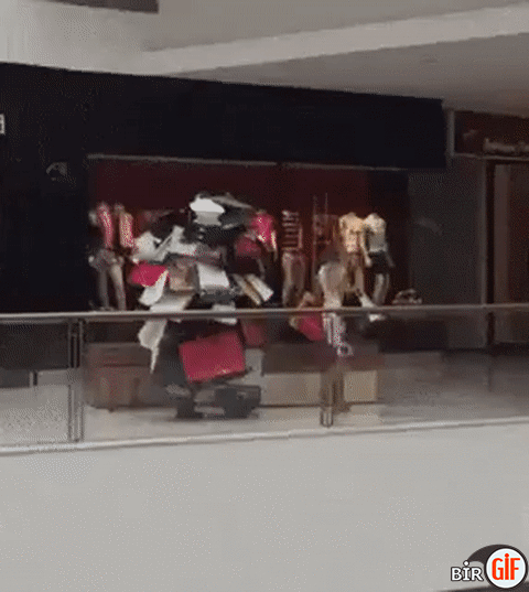 Mann trägt Taschen seiner Freundin beim Shoppen Mann trägt Taschen seiner Freundin beim Shoppen