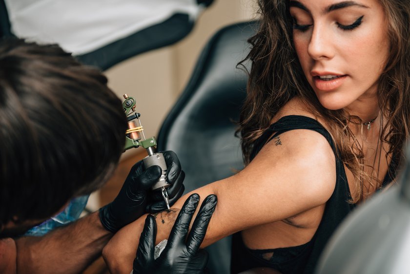 Frau lässt sich ein Tattoo stechen