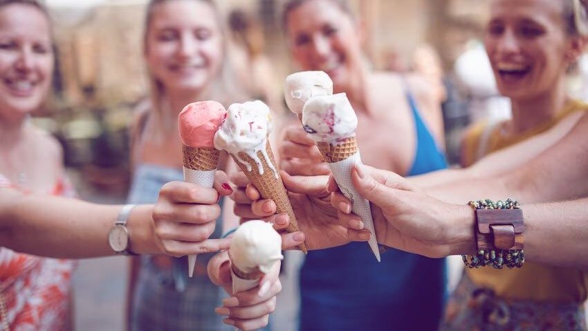Small group of women are eating ice cream in Volterra, Italy.