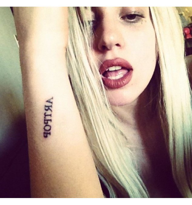 Lady Gaga streckt lasziv den Arm hoch und hat auf ihrem Unterarm ARTPOP stehen Lady Gaga streckt lasziv den Arm hoch und hat auf ihrem Unterarm ARTPOP stehen