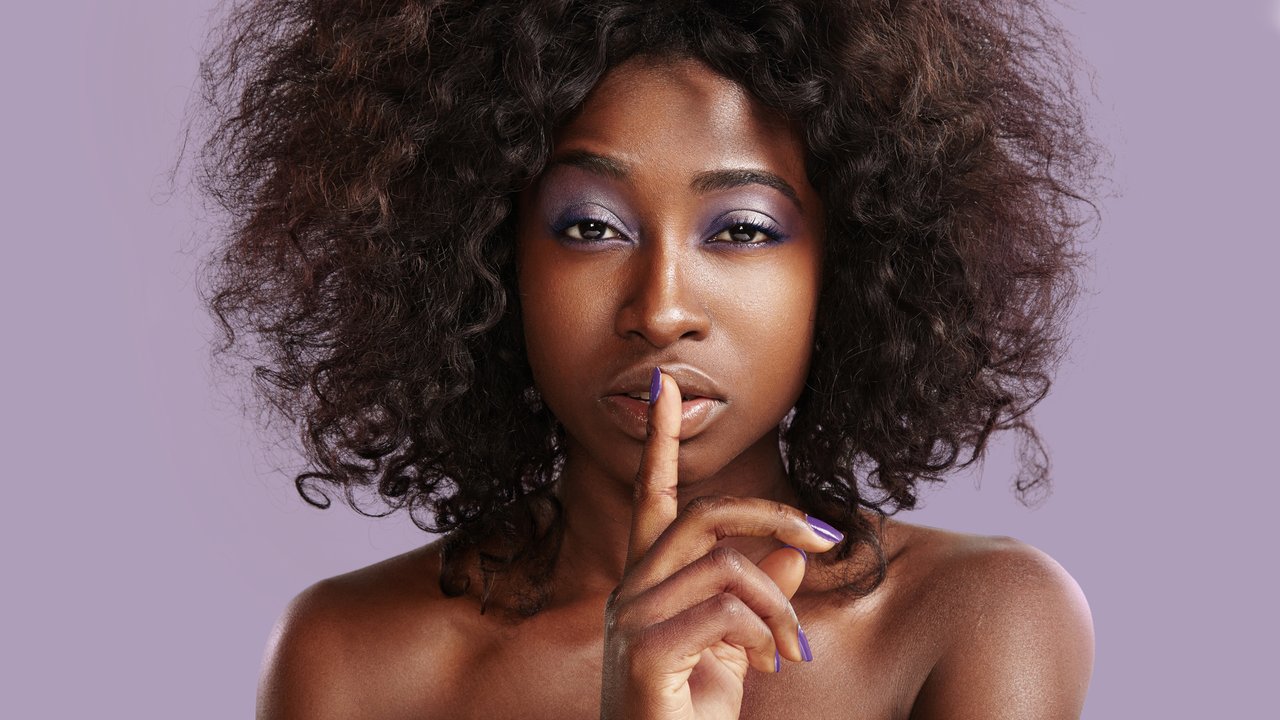 beauty black woman making shhh! on the violet background