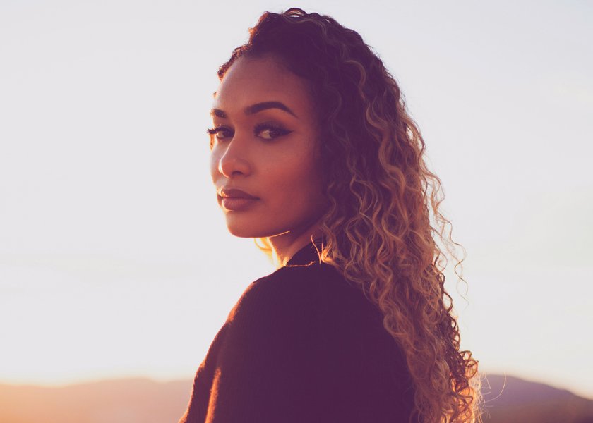 Frau, die bei Sonnenuntergang in die Kamera schaut