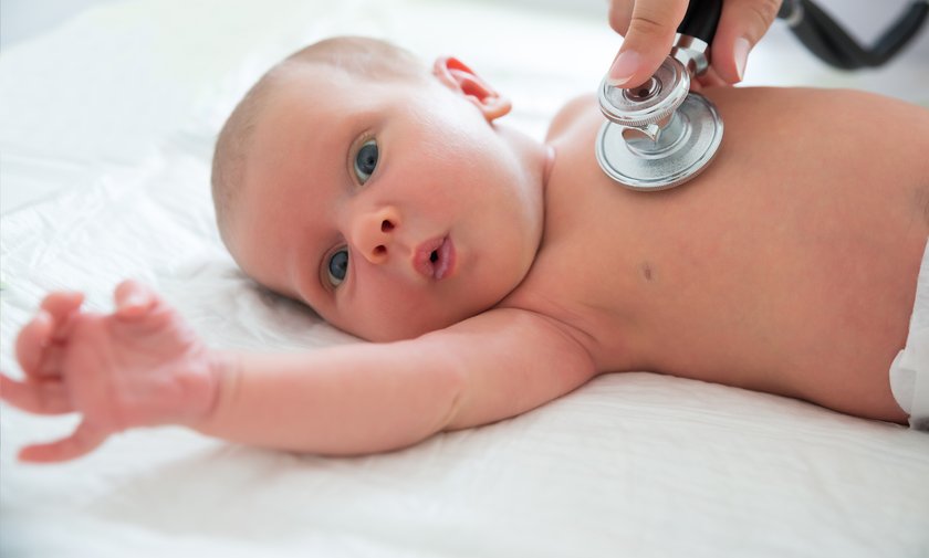 Baby wird mit einem Stethoskop abgehört